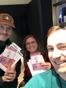 Three team members posing with their badges